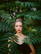 © Lyuba Burakova/Stocksy - Portrait of beautiful woman among green leaves