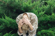 © Luis Velasco/Stocksy - Young man with floral pattern shirt on the bushes.