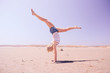 © indigo_nifght - Girl gymnast on the background of the desert, walking on his hands. The concept of a healthy lifestyle, fitness.
