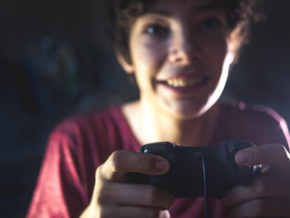 Poster - young teenager in dark bedroom playing console video game at night