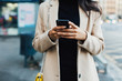 © Bonninstudio/Stocksy - Stylish woman in the city using smartphone.