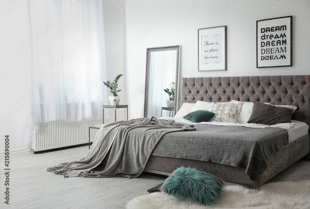 Elegant room interior with large comfortable bed - obrazy, fototapety, plakaty 