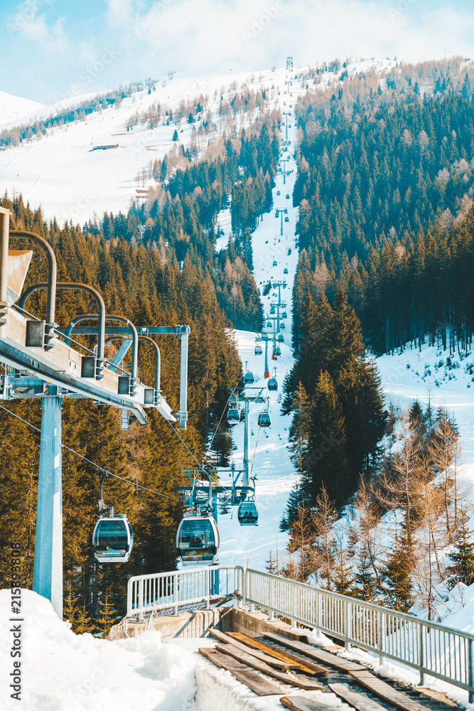 Obraz na płótnie March 20, 2018. Austria. Ski lifts and cable cars going up the mountain bringing snowboarders to ski slopes. Ski resort. w salonie