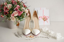Wedding Shoes For Bride. White Shoes On High Heels Near Wedding Rings, Bidal Jewelry, Garter And Wedding Invitation. Marriage Concept