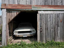 A Dirt-covered Classic Car In A Barn.
