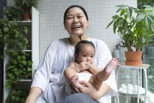 Asian Mother With Her Baby Girl In The Balcony