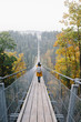 © Jovana Rikalo/Stocksy - Young woman exploring nature by walking on a long bridge in Germany