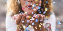 Beautiful Defocused Woman Blow Confetti From Hands. Celebration And Event Concept. Happiness And Coloured Image. Movement And Happiness Having Fun