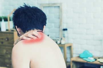 Wall Mural - Asian man back pain and sit on bed in bedroom in the morning.color tone