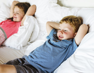 Little kids lying on the bed