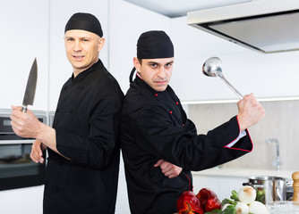 Wall Mural - Two male kitchener in uniform are standing in the kitchen