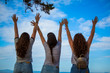 © RedThinkHead - Rear view of cheerful girls on cliff raising their arms  / Looking at view
