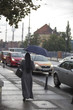 From the back of a nun with a big umbrella goes under the rain in the street of the city of Wroclaw in Poland
