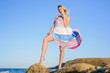© indigo_nifght - sexy blonde on the rocky coast of the sea, in a dress developing in the wind.