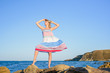 © indigo_nifght - sexy blonde on the rocky coast of the sea, in a dress developing in the wind.