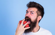 Man beard hipster strawberries fingers blue background. Mostly carbohydrates sucrose fructose glucose. Carbohydrate content strawberry. Metabolic disease. Strawberries safest fruit for sugar levels