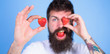 Perfect strawberry concept. Look at my berry. Man handsome hipster long beard eat hold strawberry. Hipster happy enjoy juicy strawberry blue background. Man bearded winking with red berry, defocused