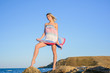 © indigo_nifght - sexy blonde on a rocky coast, playing with a dress developing in the wind.