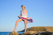 © indigo_nifght - sexy blonde on a rocky coast, playing with a dress developing in the wind.