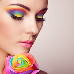 Wall Mural - portrait of beautiful young woman with rainbow rose