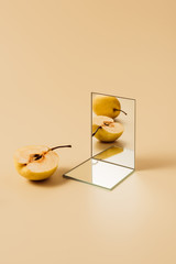 Wall Mural - yellow pears reflecting in two mirrors on beige table