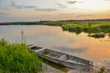 Fototapeta Pomosty - Breathtaking summer scenery with old wooden boat in warm evening sunlight.
