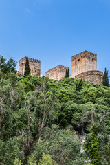 View of famous Alhambra - mediaeval Moorish palace and fortress complex from Calle Chirimias. Alhambra originally constructed as a small fortress in AD 889. Granada, Andalusia, Spain.