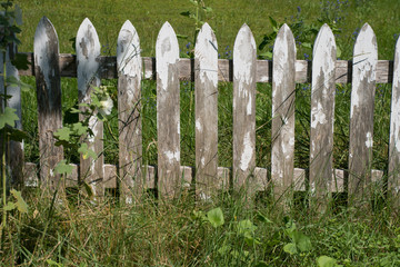 Grungy old weathered white picket fence wallpaper background