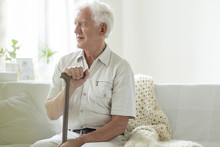 Happy Senior Man With Walking Stick Relaxing In A Nursing House