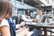 © xartproduction - Group of happy diverse male and female business people team in formal gathered around laptop computer in bright office against the background of a glass building