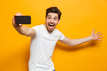 Canvas Print - Portrait of a happy young man taking a sefie