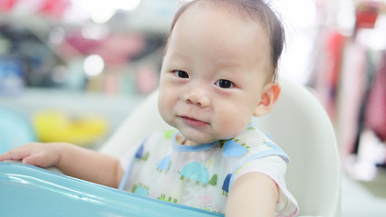 Wall Mural - The Asian little baby smile with cheerful. Preparing before having lunch.