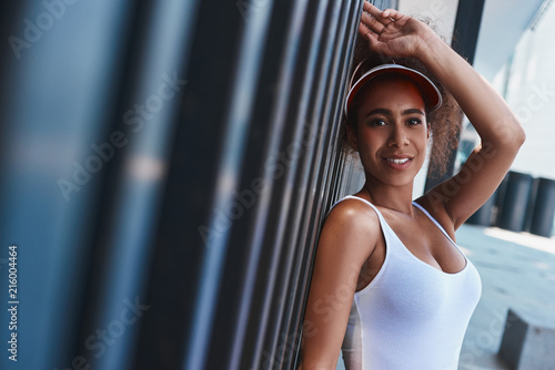 Fotografía Young woman in tennis visor free style on the street leaning on