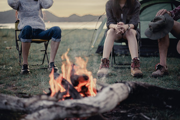 Group of friends camping.They are sitting around fire camp.