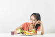 © Phawinza - Woman does not like vegetable. Unhappy woman  does not like healthy food, Emotional face.