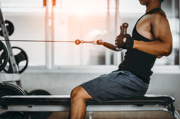 young man making low cable pulley row seated.Concept of healthy lifestyle.  bodybuilder in the gym.