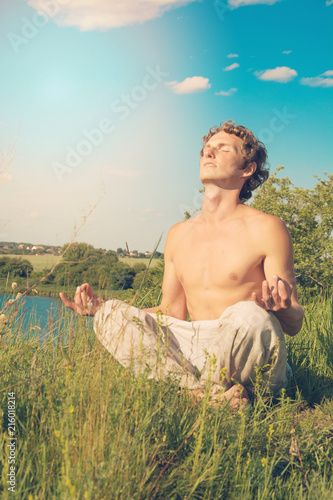 Fotografie, Obraz A peaceful young man engaged in yoga and meditation in nature.