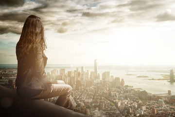 woman sitting in foreground above metropolis