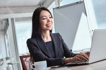 Businessperson at office alone sitting typing message joyful