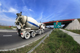 Fototapeta  - Samochód ciężarowy, gruszka z betonem na drodze pod mostem, zbliżenie.