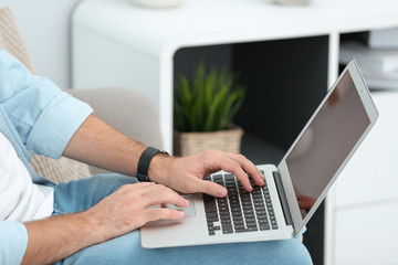 Poster - Young man working with laptop indoors, closeup