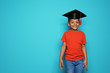 © New Africa - Little African-American school child with graduate cap on color background