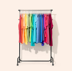mobile rack with color clothes on light background. file contains a path to isolation.