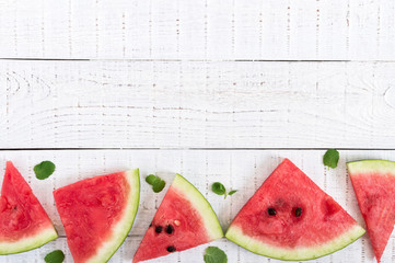Wall Mural - Juicy slices of a ripe watermelon on a white wooden background. Berry food background. Top view.  Flat lay. Free space for your project.