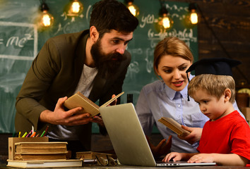 Happy teacher in classroom, Teacher puts marks sends feedbacks on email with laptop computer, Tutor sitting beside desk during private lessons at home, Student studying online courses with computer,