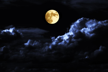 Wall Mural - Full moon over Big clouds in the skies. An alarming full moon in the night sky.