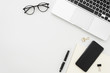 © woodpencil - Flat lay photo of office desk with laptop, smartphone, eyeglasses and notebook with copy space background. Mockup