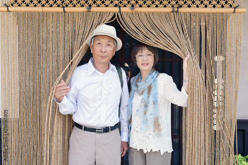 店先の暖簾をくぐる旅行中のシニア夫婦 Stock Photo Adobe Stock