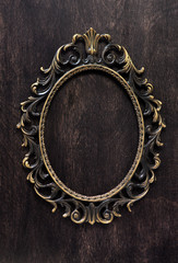 Vintage bronze frame on a wooden background, top view