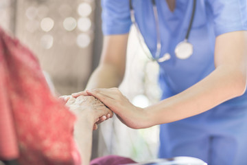 Hand of  eldery  woman with her caregiver at home. Home care or Elderly care concept.